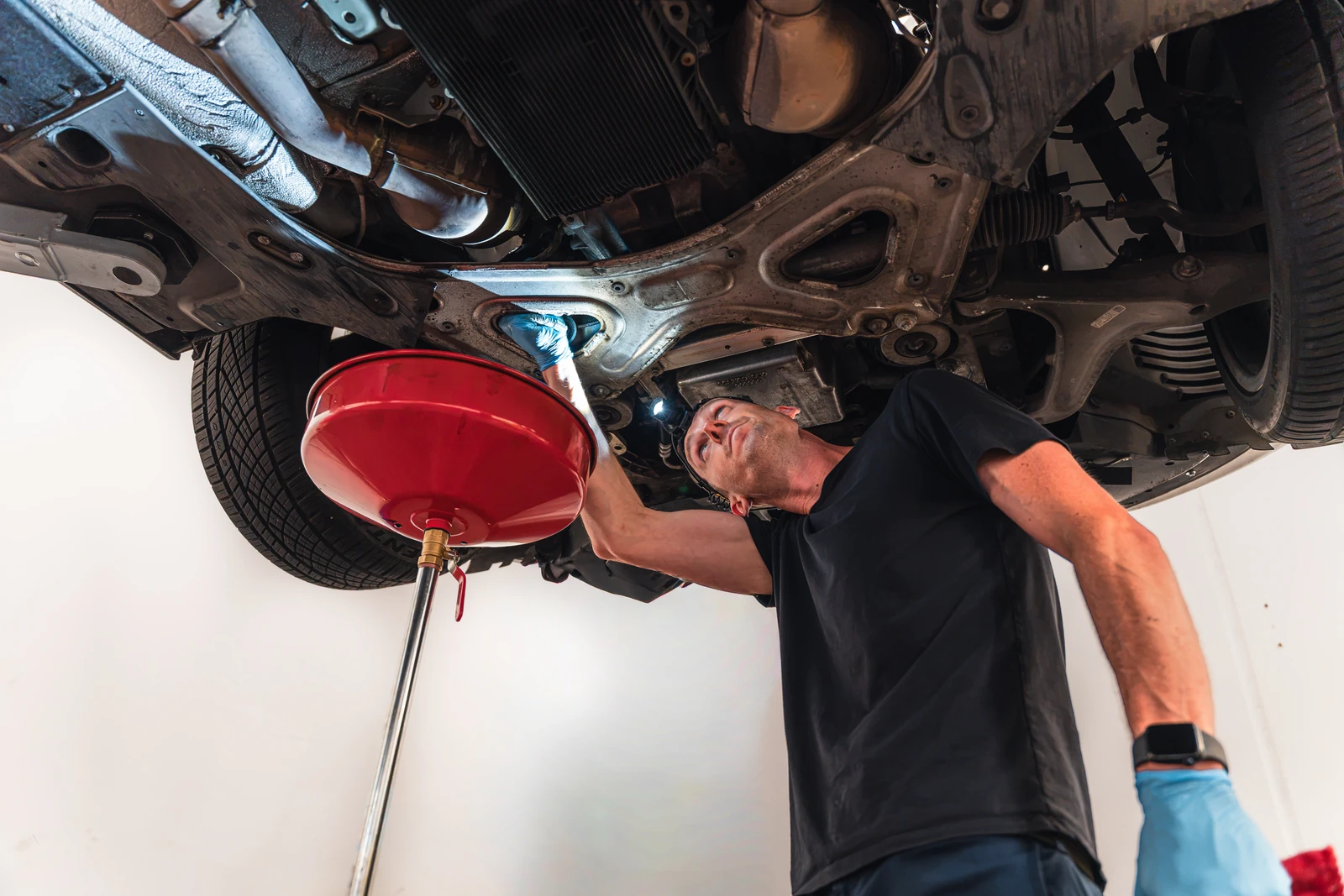 Marshall - Founder of Elite Drive Luxury Rentals inspecting fleet undercarriage